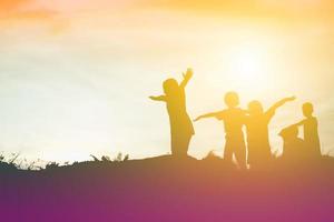 silhouette eines glücklichen kinder- und glücklichen zeitsonnenuntergangs foto