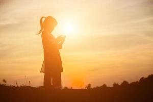 Kindersilhouette, Momente der Freude des Kindes. auf dem natursonnenuntergang foto