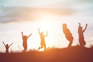 silhouette eines glücklichen kinder- und glücklichen zeitsonnenuntergangs foto