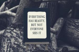 motivierendes und inspirierendes Zitat auf einer Tafel, die auf Baumstamm isoliert ist. foto