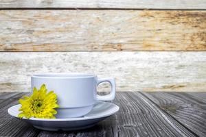 Weiße Kaffeetasse und Dahlienblüten auf Holzschreibtisch. Platz kopieren. foto