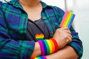 asiatische frau mit regenbogenflagge, lgbt-symbolrechten und geschlechtergleichstellung, lgbt-stolzmonat im juni. foto