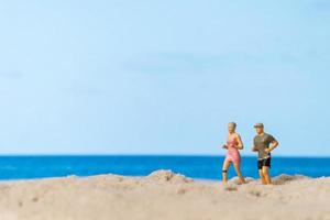 Miniaturpaar, das zusammen am Strand läuft foto