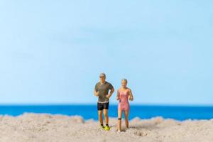 Miniaturpaar, das zusammen am Strand läuft foto