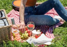 unerkennbare junge frau im park draußen an einem sonnigen tag, genießt den sommer, träumt und trinkt wein foto