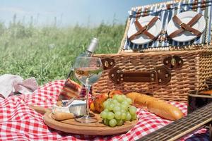 Nahaufnahme des Picknickkorbs mit Getränken und Speisen auf dem Rasen foto