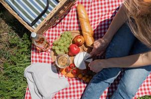 unerkennbare junge frau im park draußen an einem sonnigen tag, genießt den sommer, träumt und trinkt wein foto