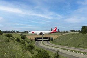 simferopol airport, ukraine, 20. juli 2021 - rotes flügel airbus a319 weißes verkehrsflugzeug auf dem flughafenvorfeld vor dem start über einen straßentunnel. foto