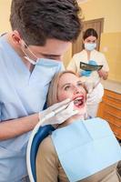 männlicher Zahnarzt und weibliche Assistentin arbeiten