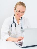 Porträt der lächelnden Ärztin mit Netbook.
