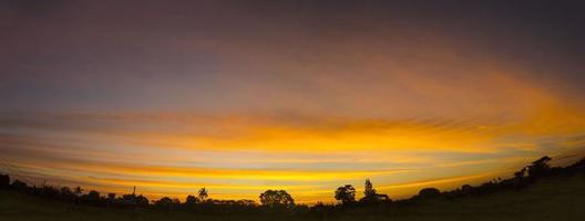 Panorama Himmel in Landschaft gelb orange und es gibt viele Farben in den schönen Abend in der ruhigen, warmen und romantischen Natur auf dem Land und im Schatten der schwarzen Kokospalmen. foto