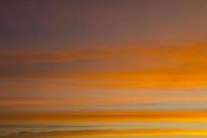 Der Himmel ist eine horizontale Linie aus gelb-orangen und farbenfrohen Farben am schönen Abend inmitten der Natur, die auf dem Land friedlich, warm und romantisch ist und äußerst schön ist. foto