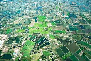 der blick auf die grüne wiese und den bauernhof und die innenstadt der stadt mitten in thailand. es schoss aus dem Düsenflugzeug. foto