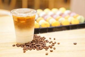 Latte mit Kaffeebohnen auf dem Holztisch mitnehmen foto