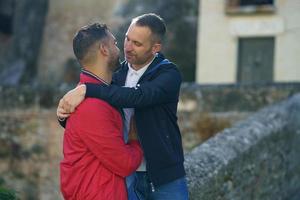 Paar schwule Männer, die sich in der Stadt umarmen foto