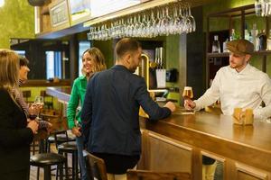 Kunden und Barkeeper in einer eleganten Bar foto