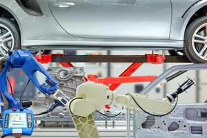 industrielle roboterarbeit mit autoteilen auf unscharfem steuerungshintergrund foto