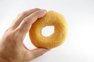 Hand wird ein Donut gefangen foto