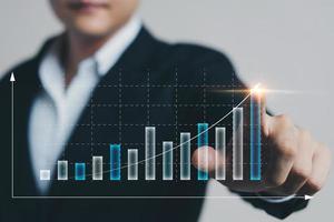 geschäftsmann, der virtuelle bildschirmdiagrammanalyse des geschäftswachstums und der investitionen berührt, strategische planung zur steigerung der verkaufsgewinne, langfristiger geschäftsplan. foto