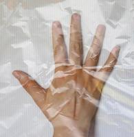 Hand einer jungen Frau, die in Plastikfolie eingewickelt ist und verschiedene Gesten zeigt foto