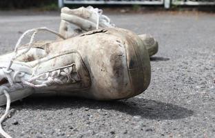 Konzept der alten Schuhe, die auf einer Ashpalt-Straße mit Kopierplatz für Text zurückgelassen wurden. foto