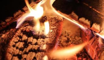 Schönes rotes und orangefarbenes heißes brennendes Feuer in einem Kamin foto