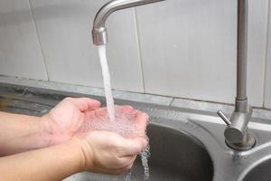 beide hände werden wasser zum waschen der hände unterzogen.hygienekonzept. foto