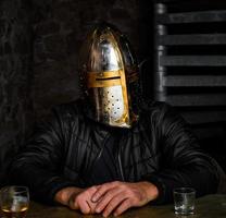 ein Mann mit einem mittelalterlichen eisernen Ritterhelm. foto