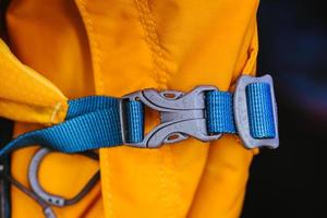 Nahaufnahmedetail des gesperrten blauen praktischen Plastikverschlusses des gelben Rucksacks. foto