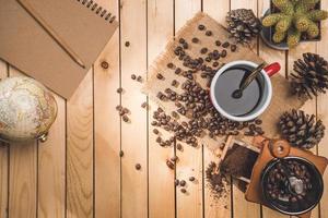 tasse kaffee, bohnen rotieren und zutaten für die kaffeezubereitung und zubehör mit kartenwelt. Entspannen Sie sich foto
