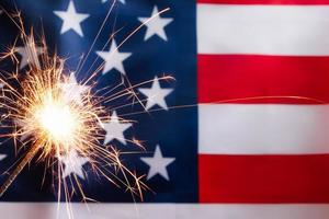 Konzept zum Feiern der Unabhängigkeit oder des Gedenktages. Wunderkerze auf dem Hintergrund der amerikanischen Flagge. foto