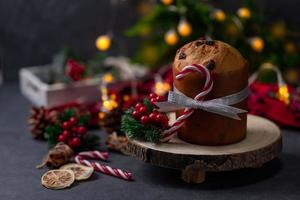 traditioneller weihnachtspanettone-kuchen mit getrockneten früchten auf dunklem steinhintergrund