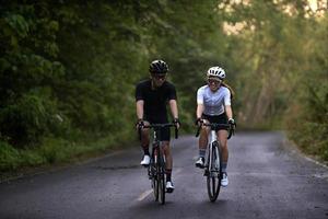 Glückliches Paar radelt oder fährt Fahrrad auf dem Land für einen gesunden Lebensstil foto