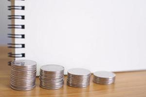 Geschäfts- und Finanzkonzept und Notizblöcke und Münzen auf Holztisch. foto