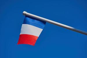 französische Flagge gegen wolkenlosen blauen Himmel foto