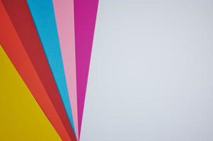 sechs farbige Papiere fächerförmig auf ein weißes Papier als Hintergrundfoto gelegt foto