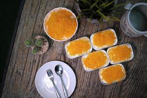 Foythong-Kuchen im Folienbecher auf Holztisch foto