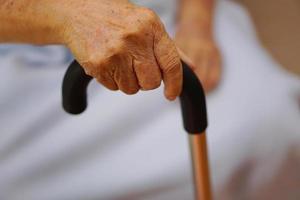 die Hand einer älteren Frau oder einer älteren Person oder einer alten Frau, die den Rollator zur Unterstützung auffängt. gesundheitswesen und medizinisches konzept. foto