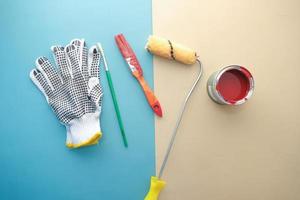 Draufsicht auf einen Pinsel, Handschuhe und Farbe auf dem Tisch foto