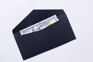 100 Dollar Bargeld in einem Umschlag auf einem Schreibtisch foto