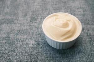 Nahaufnahme von Mayonnaise im Behälter auf dem Tisch. foto