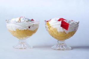 Eis mit Mangogeschmack in einem Glas auf weißem Hintergrund foto