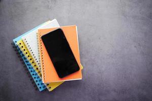 Draufsicht auf Smartphone und Notizblock auf dem Tisch foto