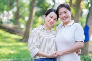Porträt der asiatischen Mutter und Tochter im Park foto