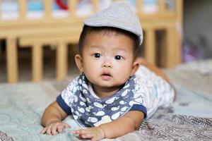 asiatisches baby, das auf bett liegt. foto