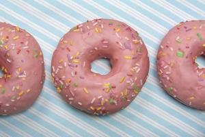 rosa Donut auf blau gestreiftem Hintergrund