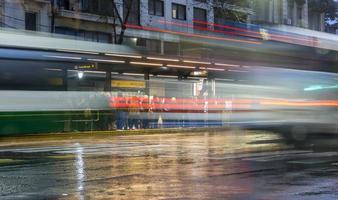 Buenos Aires, Argentinien. 2019. Langzeitbelichtung von öffentlichen Verkehrsmitteln, nasser Straße und blauer Stunde foto