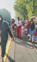 Sukoharjo - 18. Mai 2022 - ein alter Mann, der ein Fahrrad auf einer belebten Straße voller Menschen schiebt foto