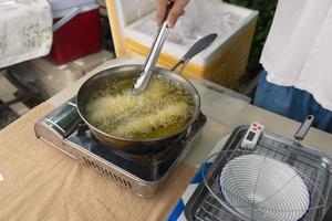 Churros werden in kochendem Öl in einer Pfanne gebraten. Konzept Kochen Hintergrund. foto
