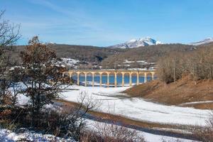 Eisenbahnbrücke über das verschneite Tal foto